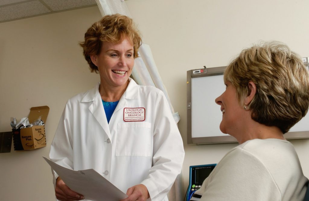 A doctor talking with a smiling patient in a consulting room
