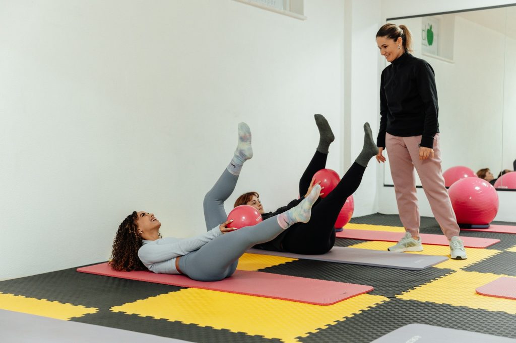 A physiotherapist guiding women through floor exercises