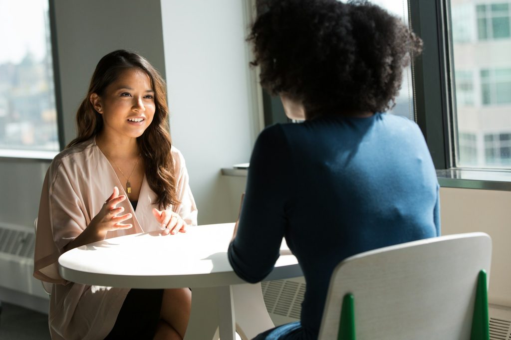 Two women talking in a bright therapy room